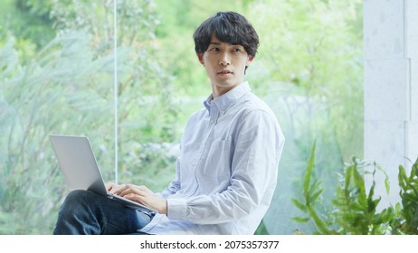 Asian young man working with a computer - Shutterstock ID 2075357377