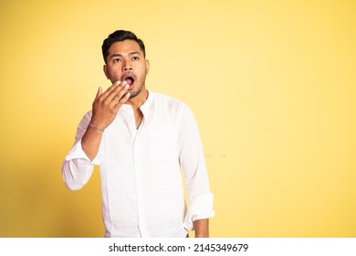 Asian Young Man Yawning With Hand Covering Mouth