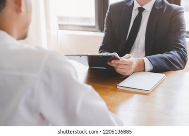 Asian young manager, employer man interview with person, have question about resume and listen to candidate answer, conversation together at office. Recruitment employee job concept.