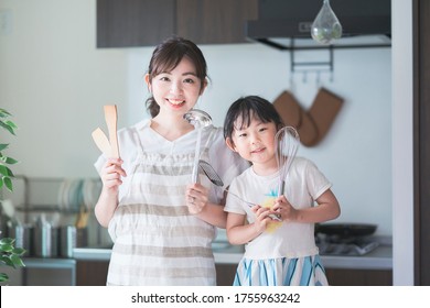 Asian Young Mom And Daughter Challenge Cooking With Kitchen Tools