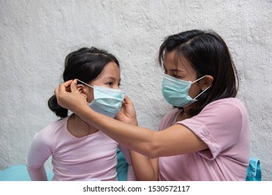 Asian Young Mother And Children Daughter Wearing Protective Mask, Maybe Coughing Until Sore Throat, Difficulty Swallow, Cold, Flu Or Fever Go To The Hospital Meet A Doctor