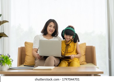 Asian Young Mother With Computer Notebook Teaching Kid To Learn Or Study Online At Home, Homeschooling Online Concept