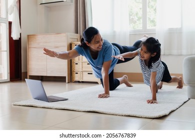 Asian Young Mother And Her Daughter Doing Stretching Fitness Exercise Yoga Together At Home. Parent Teaching Child Work Out To Be Strong And Maintain Physical Health And Wellbeing In Daily Routine.