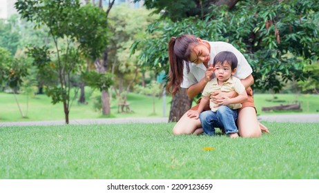 Asian Young Mother Holding Her Little Son The Boy Was Irritable And Overbearing In Park.