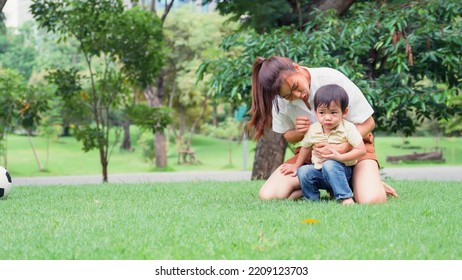 Asian Young Mother Holding Her Little Son The Boy Was Irritable And Overbearing In Park.