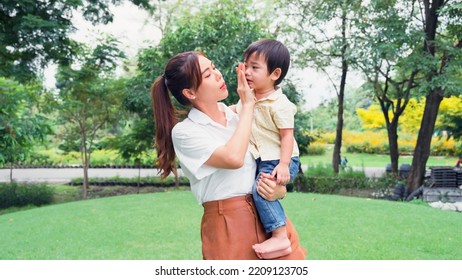 Asian Young Mother Holding A Little Son Of Her Being Irritable And Overbearing In Park.