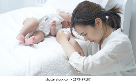 Asian young mother worrying about child rearing. Postpartum depression.