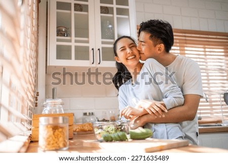 Asian young new marriage couple spend time together in kitchen at home. Attractive man and woman feeling happy and relax, enjoy cooking foods for breakfast with happiness. Family relationship concept.