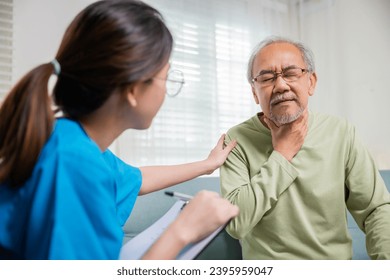 Asian young nurse checking senior man neck pain in clinic at retirement home, doctor woman examines lymph nodes on neck to determine if swollen, sore throat - Powered by Shutterstock