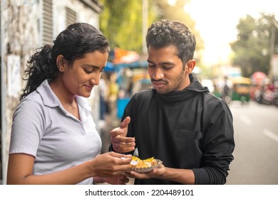 Asian young people eating snacks or chats in food street . Loving , Dating , Food , Lifestyle. - Powered by Shutterstock