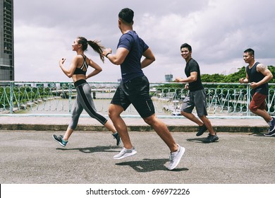 Asian Young People Running On The Bridge Together