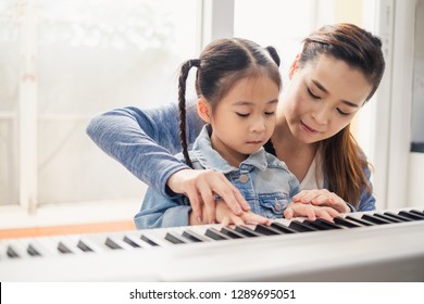 Asian Young Pianist Teacher Teaching Girl Kid Student To Play Piano, Music Education Concept