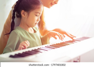 Asian Young Pianist Teacher Teaching Little Girl Student To Play Piano, Music Education Concept.