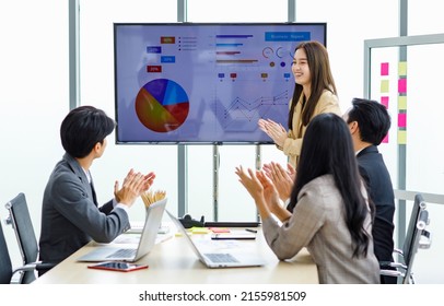 Asian young pretty professional successful businesswoman staff standing greeting say thank you when finishing presentation while male and female colleagues clapping hands together admire compliment. - Shutterstock ID 2155981509