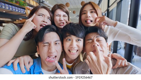 Asian Young Six Friends Taking Selfie And Making Funny Face In Restaurant Happily