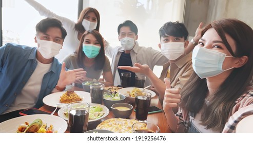 asian young six friends wearing face mask taking selfie in restaurant happily