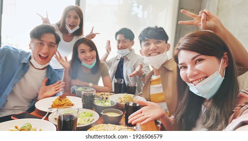 Asian Young Six Friends Wearing Face Mask On Chin Taking Selfie In Restaurant Happily