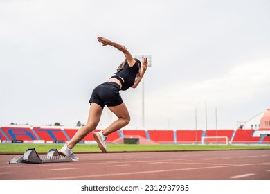 Asian young sportswoman sprint on a running track outdoors on stadium. Attractive strong athlete girl runner exercise and practicing workout speed running marathon on the race for olympics competition - Powered by Shutterstock