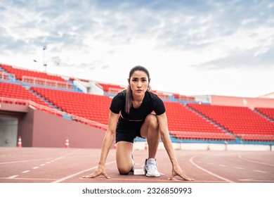 Asian young sportswoman sprint on a running track outdoors on stadium. Attractive strong athlete girl runner exercise and practicing workout speed running marathon on the race for olympics competition