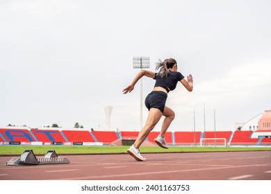 Asian young sportswoman sprint on a running track outdoors on stadium. Attractive strong athlete girl runner exercise and practicing workout speed running marathon on the race for olympics competition - Powered by Shutterstock