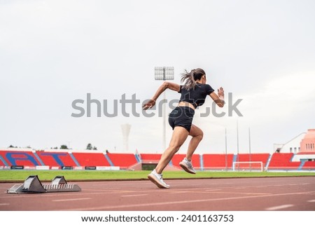 Asian young sportswoman sprint on a running track outdoors on stadium. Attractive strong athlete girl runner exercise and practicing workout speed running marathon on the race for olympics competition