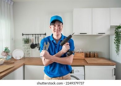 An Asian young Technician service man wearing blue uniform checking electrical appliances in home - Powered by Shutterstock