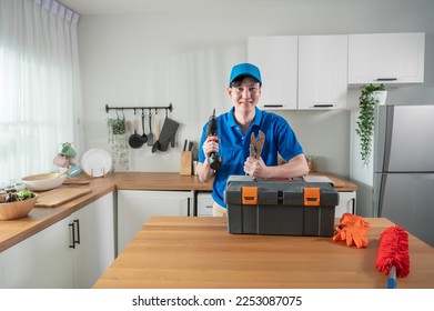 An Asian young Technician service man wearing blue uniform checking electrical appliances in home - Shutterstock ID 2253087075