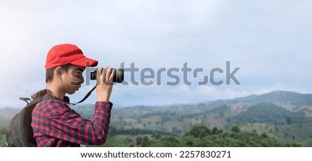 Asian young teen boy holds binoculars in hands and he is going  to watch the birds which flying on the sky, fish in the river and wild beasts walking and climbing trees that cannot be seen with eyes.
