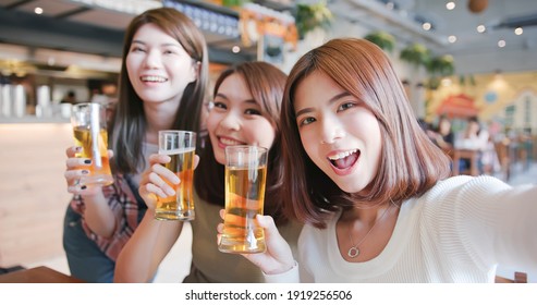 asian young three women friends taking selfie in restaurant happily - drinking and toasting beer