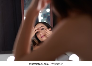 Asian Young Woman Applying Black Eye Liner