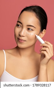 Asian Young Woman Applying Eye Lifting Cream. 