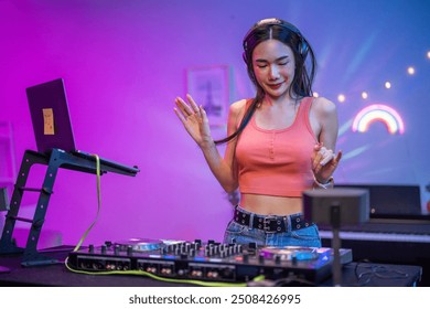 Asian young woman artist DJ mixing and scratching music mixer controller. Attractive female musician DJ having fun mixing music on console touching buttons and playing electronic music at neon party. - Powered by Shutterstock