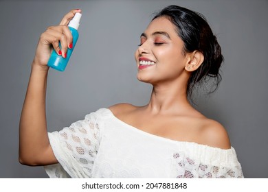 Asian Young woman with bottle spraying on her face. side face portrait isolated on gray background. skin care product. - Shutterstock ID 2047881848