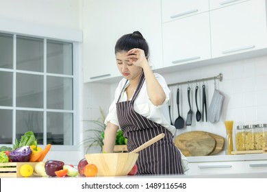 Asian Young Woman Cooking In The Kitchen.With Stress