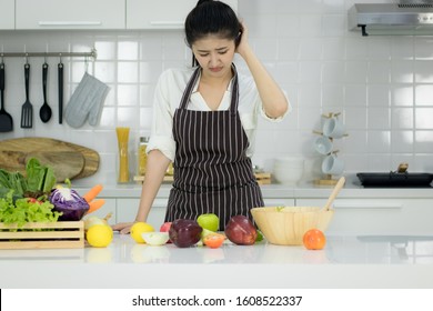 Asian Young Woman Cooking In The Kitchen.With Stress