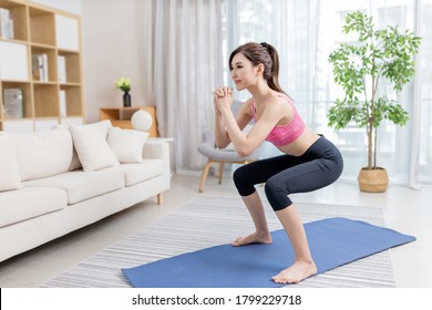 Asian Young Woman Is Doing Squats Exercise At Home