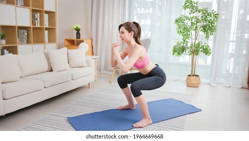 Asian Young Woman Is Doing Squats Exercise At Home