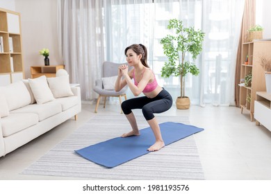 Asian Young Woman Is Doing Squats Exercise At Home