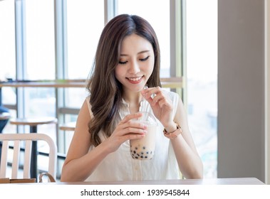 Asian Young Woman Drink Bubble Tea In The Restaurant