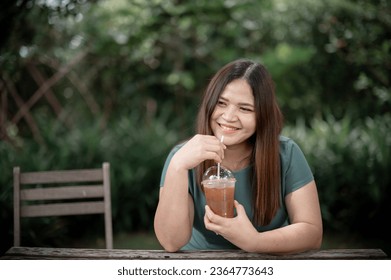 Asian young woman drinking green tea and thinking about something during coffee break at cafe - Shutterstock ID 2364773643