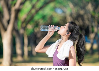 Asian Young Woman Drinking Water After Jogging