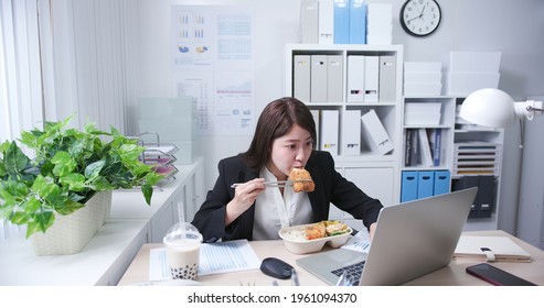 Asian Young Woman Eat Her Lunch And Tapioca Ball Tea While She Is Working In The Office
