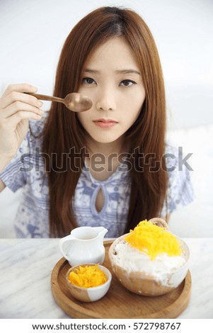 Asian young woman eating Shaved ice with milk and coconut