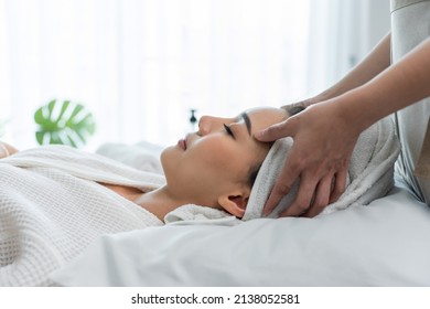 Asian Young Woman Feel Happy And Relax During Facial And Head Massage. Attractive Beautiful Girl Lying On Massage Table, Getting Physiotherapy From Masseuse For Skin And Body Care In Spa Beauty Salon.