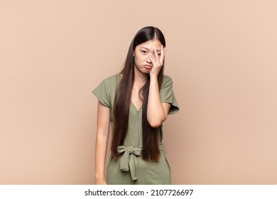 asian young woman feeling bored, frustrated and sleepy after a tiresome, dull and tedious task, holding face with hand - Shutterstock ID 2107726697