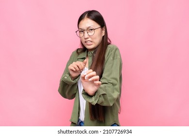 Asian Young Woman Feeling Disgusted And Nauseous, Backing Away From Something Nasty, Smelly Or Stinky, Saying Yuck