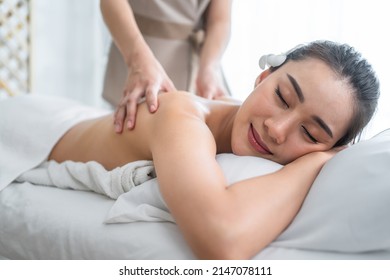 Asian Young Woman Feeling Happy And Relax During Back Massage With Oil. Attractive Beautiful Girl Lying On Massage Table, Getting Physiotherapy From Masseuse For Skin And Body Care In Spa Beauty Salon