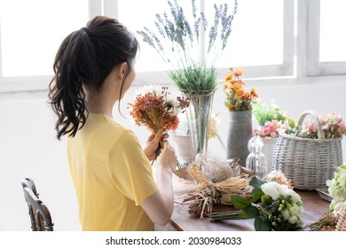 Asian Young Woman With Flower Arrangement.