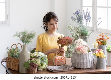 Asian Young Woman With Flower Arrangement.