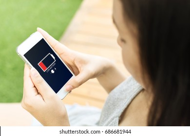 Asian Young Woman Hand Holding Mobile Phone With Low Battery On Screen